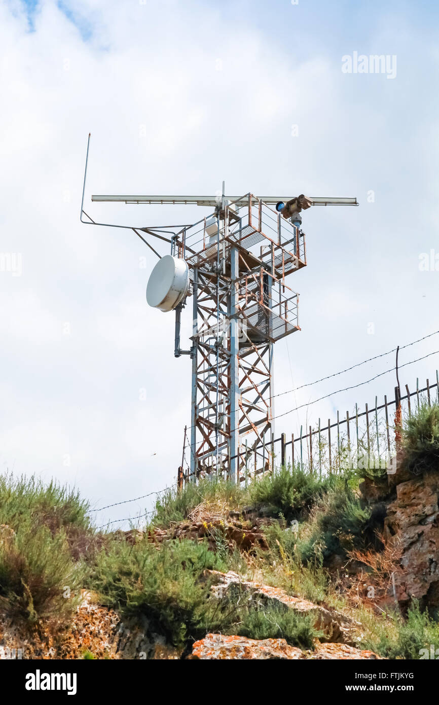 La station radar d'observation tower avec différents appareils et caméras au-dessus de blue cloudy sky Banque D'Images