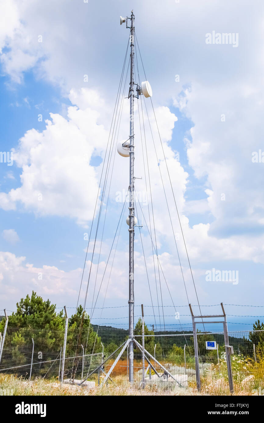 La tour de radio de télécommunication avec les dispositifs ci-dessus ciel nuageux Banque D'Images