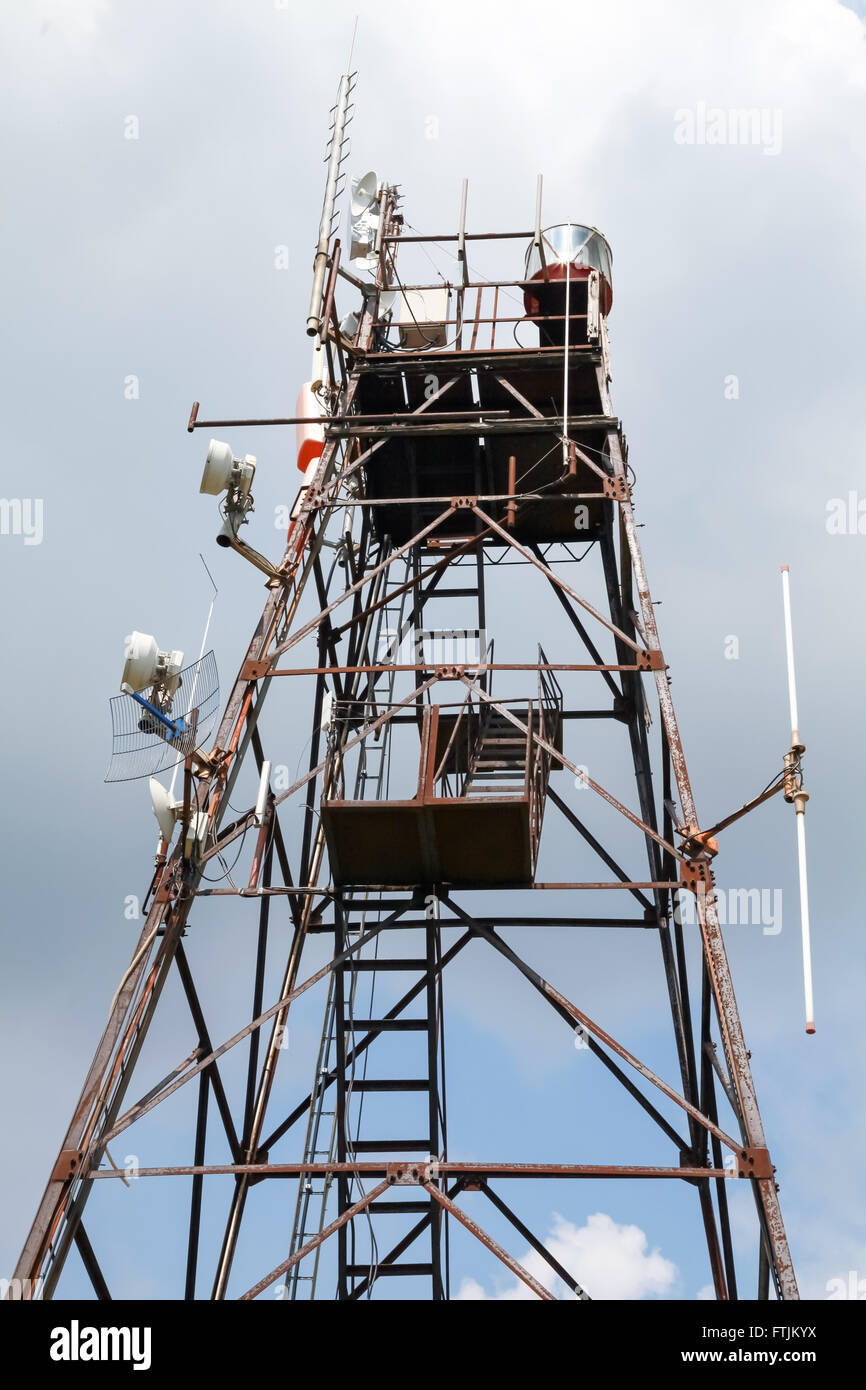 La tour de radio télécommunication avec différents appareils émetteurs et récepteurs au-dessus de ciel nuageux Banque D'Images