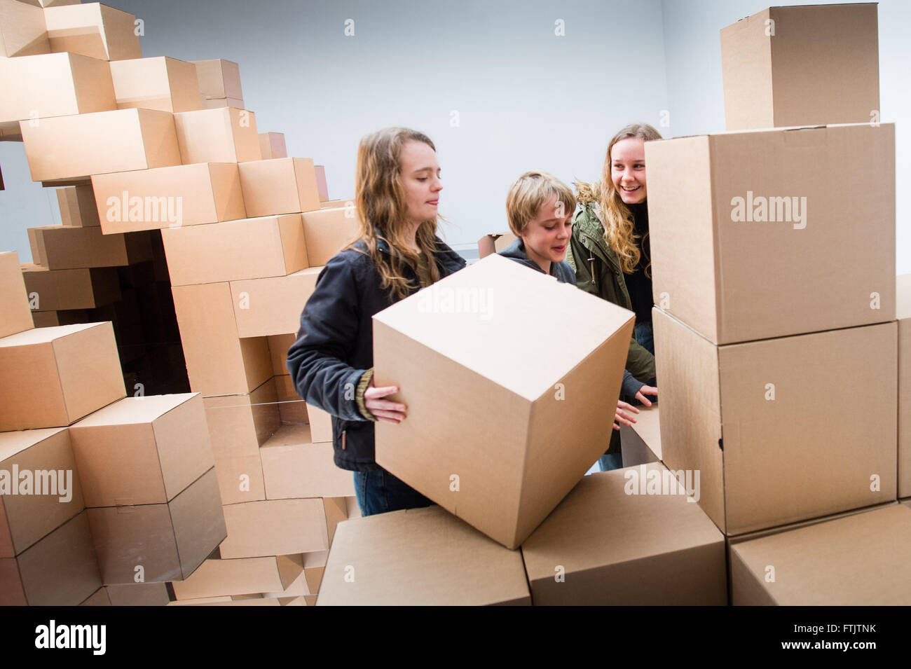 Pays de Galles Aberystwyth UK, 29 mars 2016 vacances de Pâques sur les enfants jouant dans et avec l'énorme 'Hollow' installation de boîtes en carton rejoint magnétiquement par artiste Jenny Hall à Aberystwyth Arts Centre. En prenant une mine de cuivre comme une source d'inspiration cette exposition explore la destruction créatrice qui participent à l'acte de construire. La mine est représentée comme une grande sculpture creuse dans la galerie et les boîtes de carton représentent le 'plus' qui a été extraite de l'intérieur. Credit : Keith morris/Alamy Live News Banque D'Images