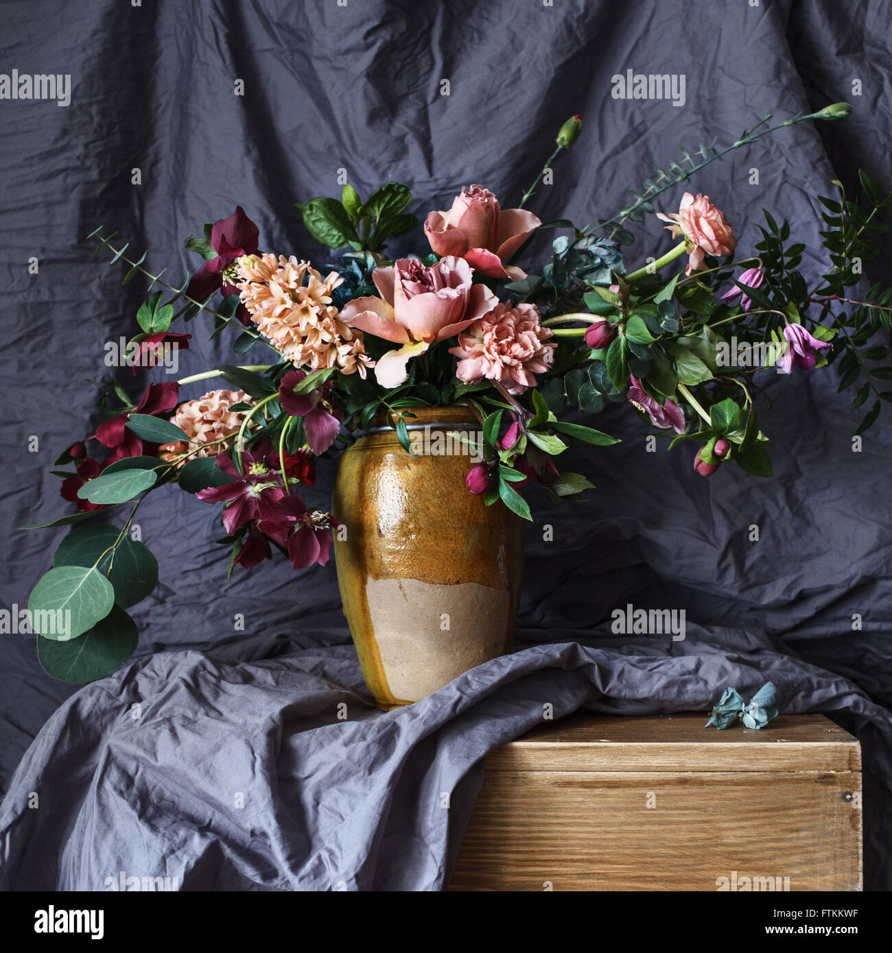 Fleur dans le vase sur la table sur l'arrière-plan de tissu gris Banque D'Images