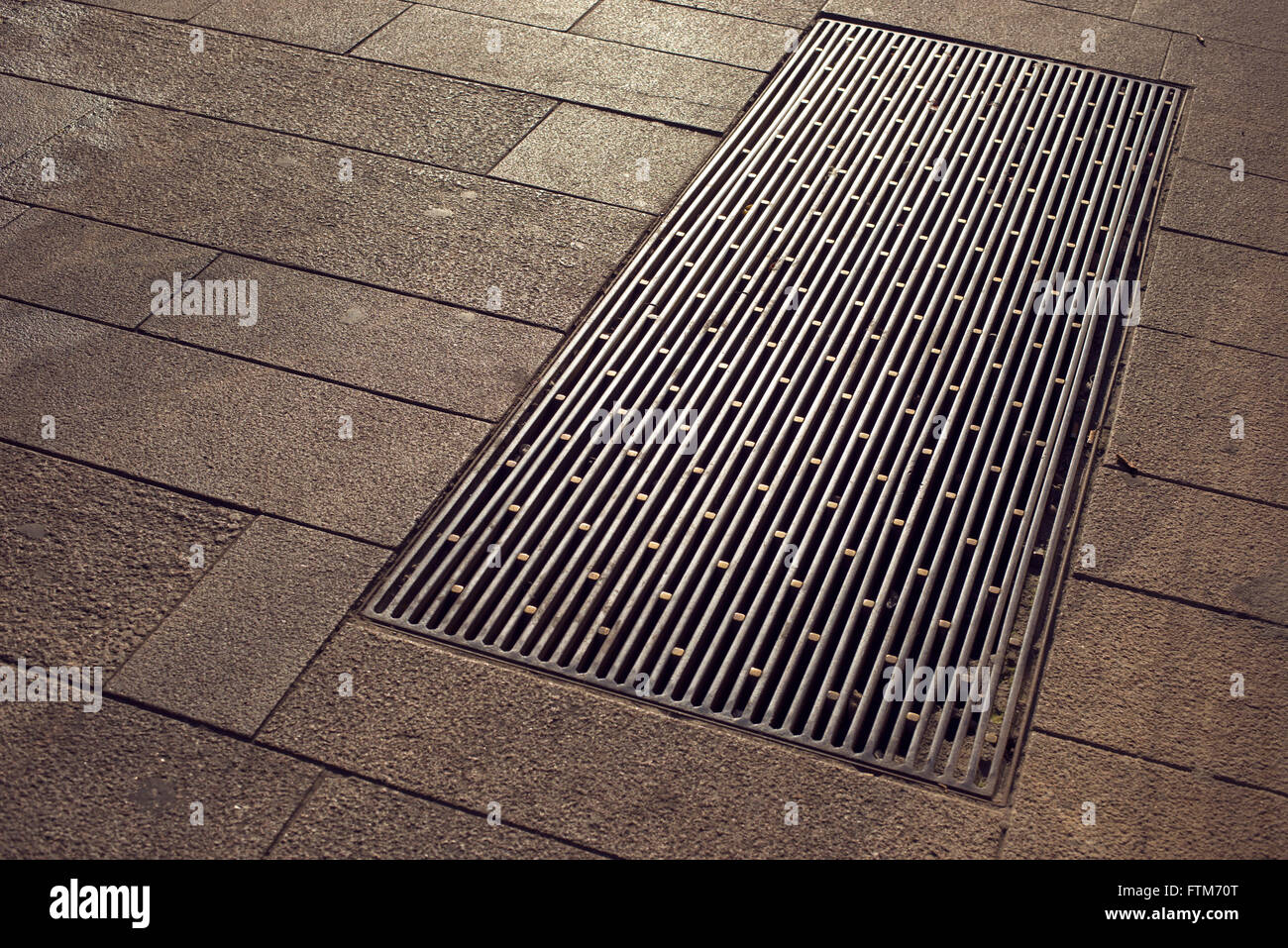 Sol carrelé city pavement avec fragment métallique grande berline de drainage Banque D'Images