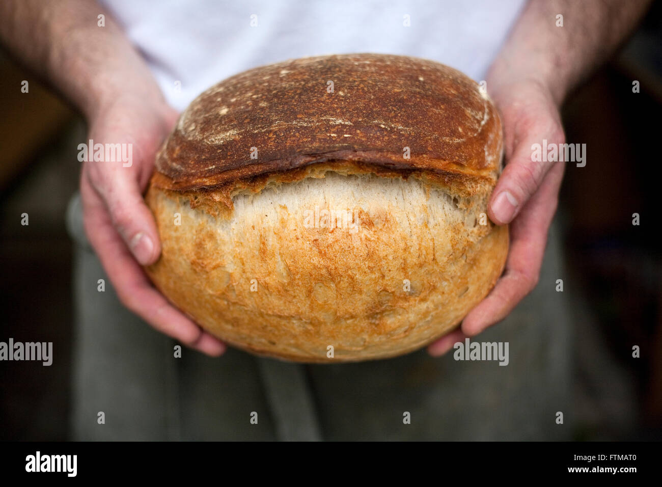 Un boulanger est titulaire d'une miche de pain de soude dans ses mains Banque D'Images