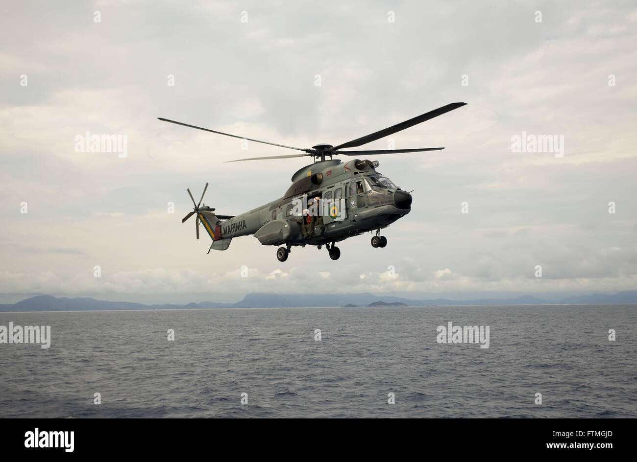 Hélicoptère Super Puma de la marine brésilienne survolant l'île de l'océan Atlantique en fin de Trinidad Banque D'Images