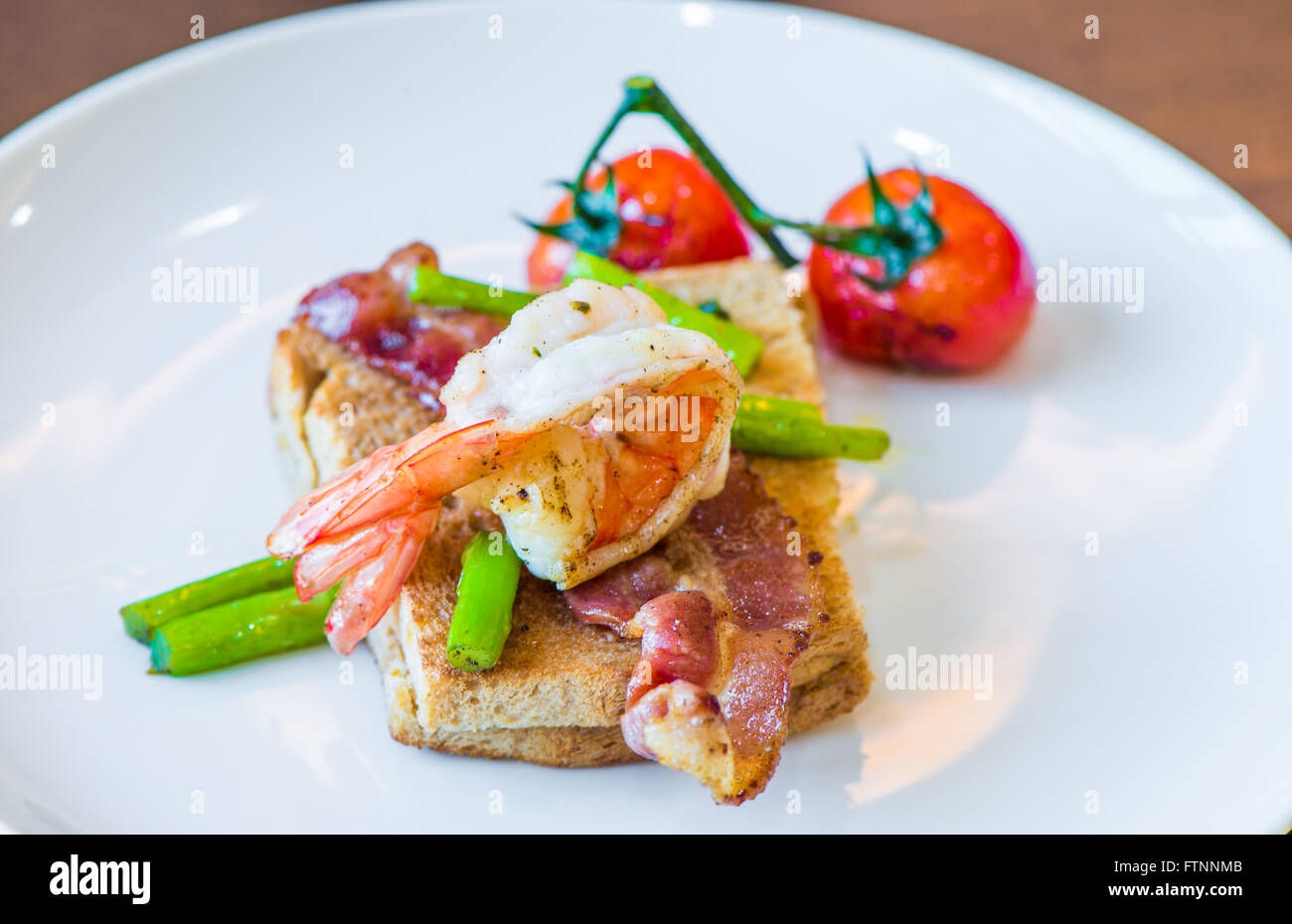 Sandwich avec oeuf poché, jambon de parme et tomates Banque D'Images