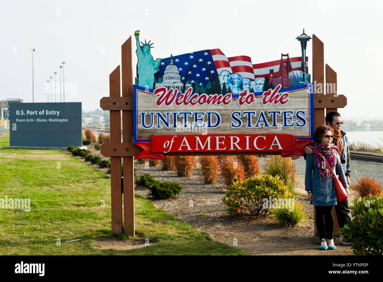 Les touristes asiatiques qui pose pour une photographie à l'accueil sign in Peace Arch Park sur la frontière USA/Canada, Blaine, Washington USA Banque D'Images