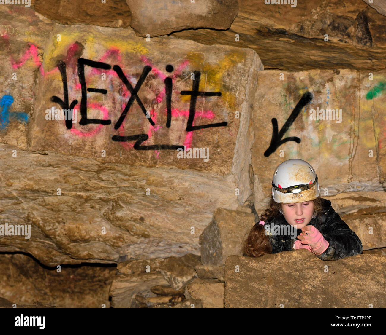 Casque d'escalade dans l'enfant dans une mine souterraine, par "Quitter" signe. Peint à la bombe une direction dans une ancienne mine de calcaire Banque D'Images