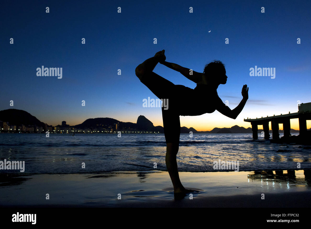 Mulher em posent de yoga na Praia de Copacabana ao amanhecer - zona sul Banque D'Images