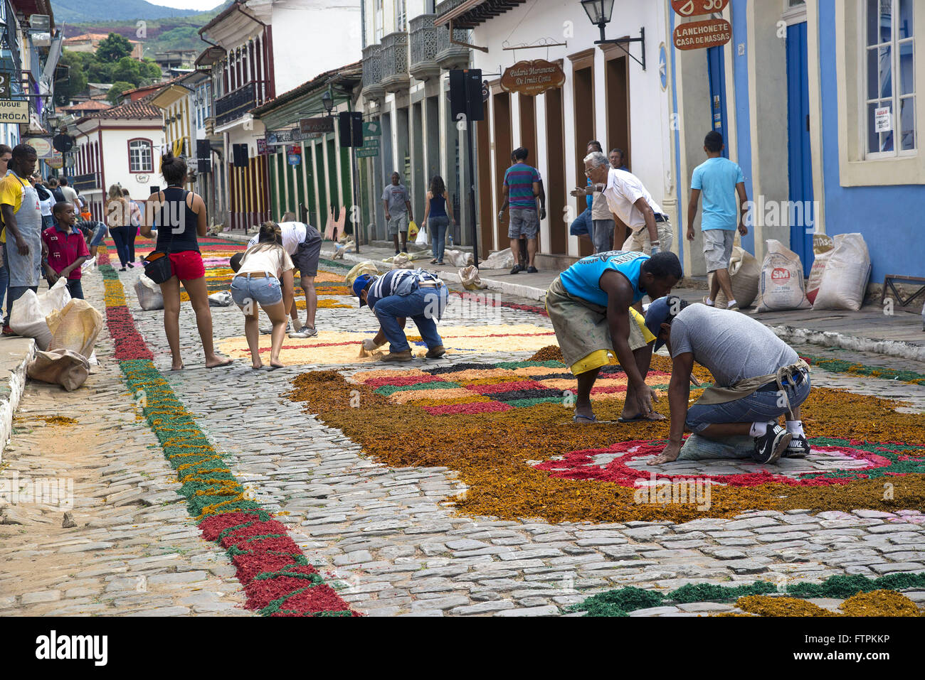 Fieis decorando rua de serragem com tapetes para colorida procissao da Semana Santa Banque D'Images