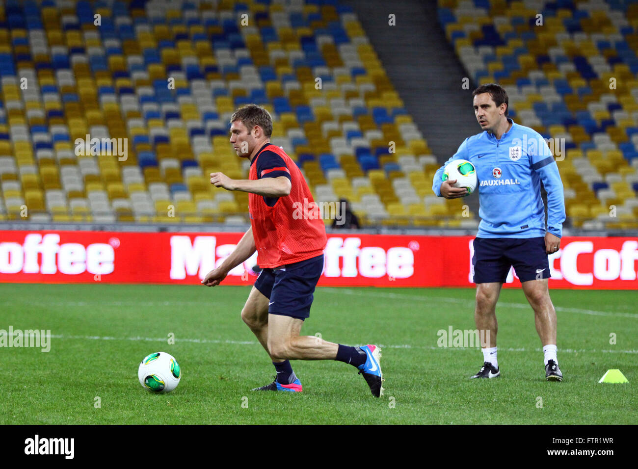 Kiev, UKRAINE - septembre 9, 2013 : James Milner (L) et l'entraîneur Gary Neville de l'Angleterre s'exécuter pendant la session de formation au stade olympique NSC avant la Coupe du Monde FIFA 2014 Jeu de qualification contre l'Ukraine Banque D'Images