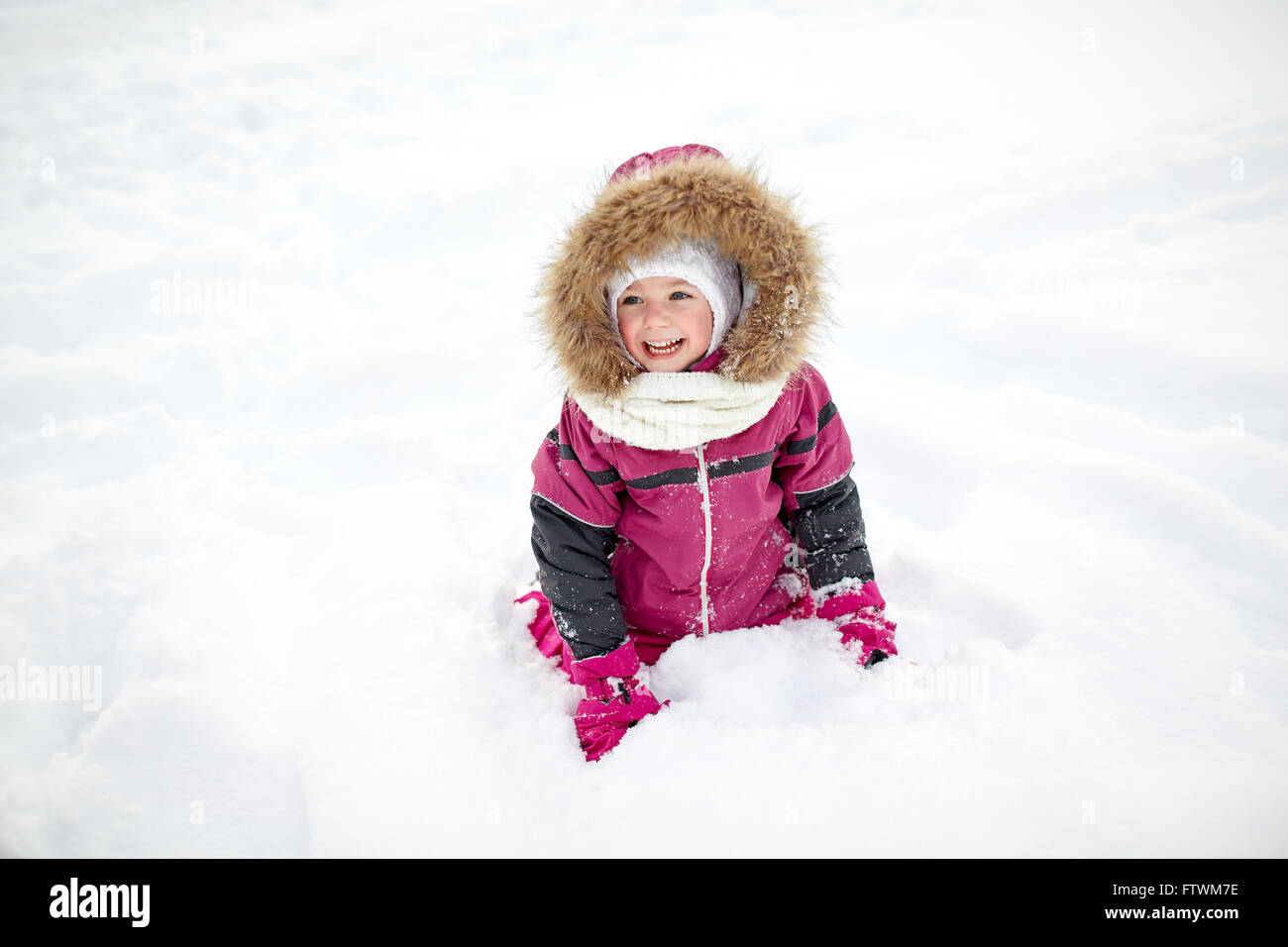 F heureux petit enfant ou d'une fille avec de la neige en hiver Banque D'Images