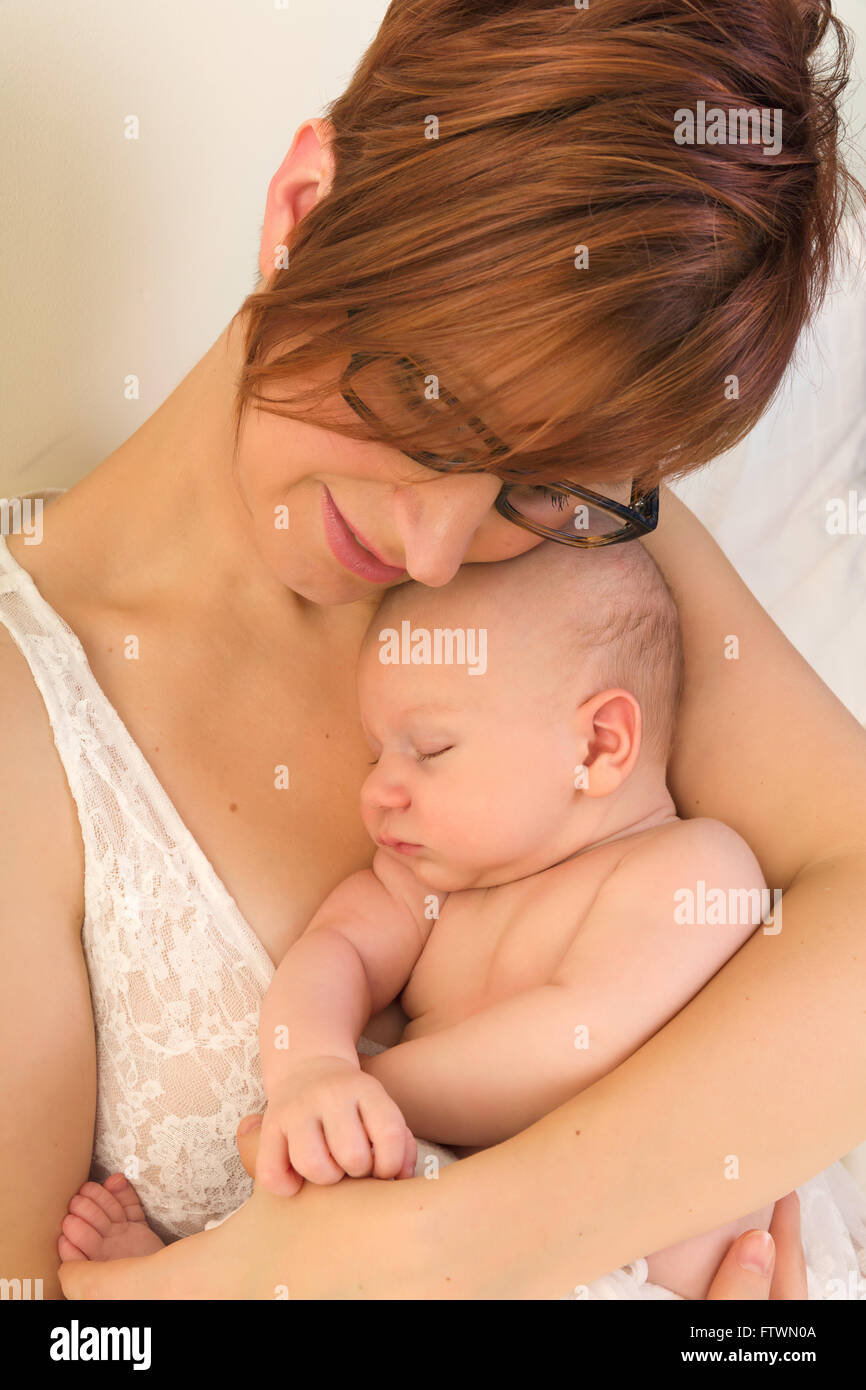 Jeune maman tenant son bébé endormi après l'allaitement Banque D'Images