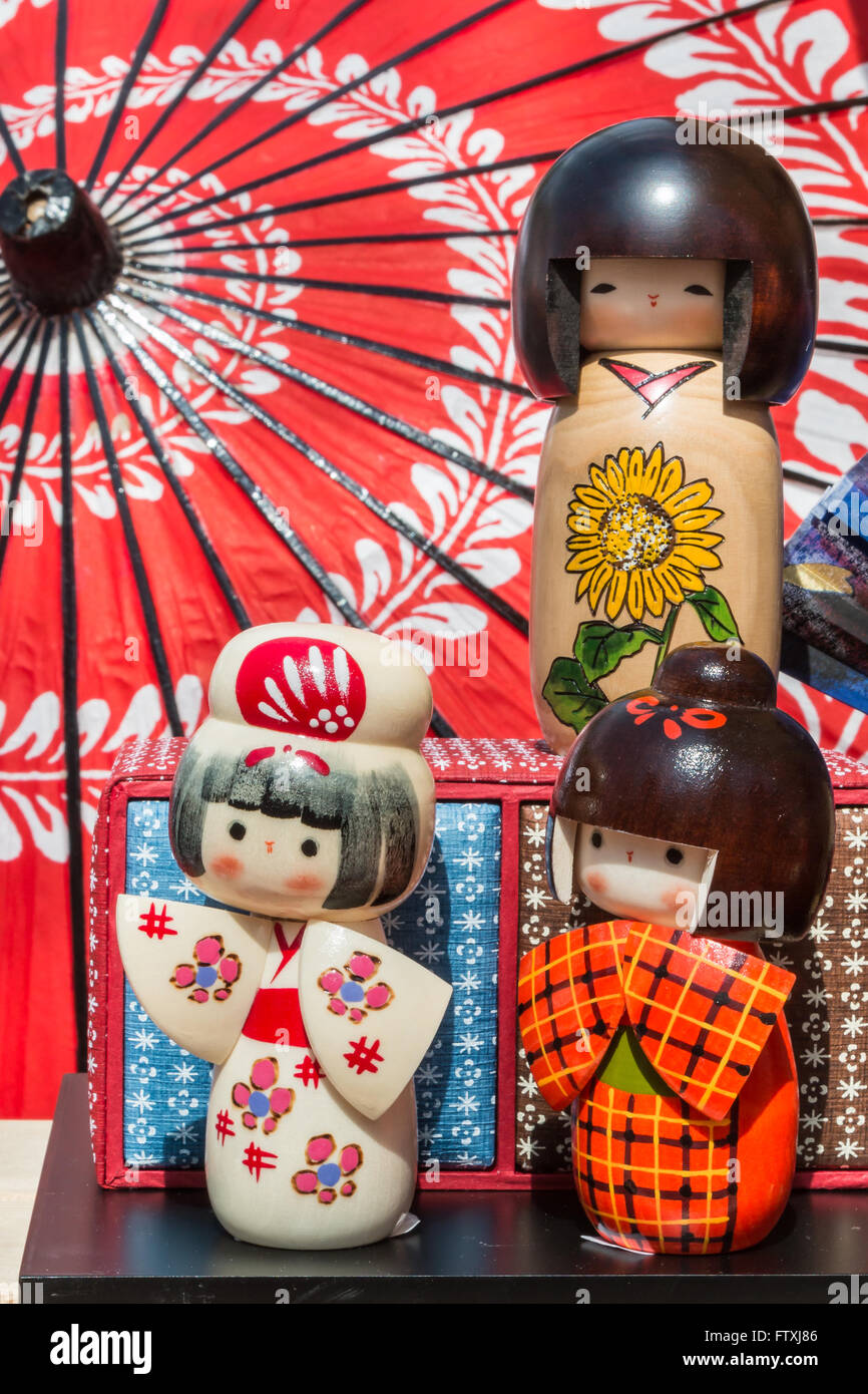 Poupées de Kokeshi en bois traditionnel japonais et parapluie wagasa en arrière-plan, de souvenirs touristiques Banque D'Images