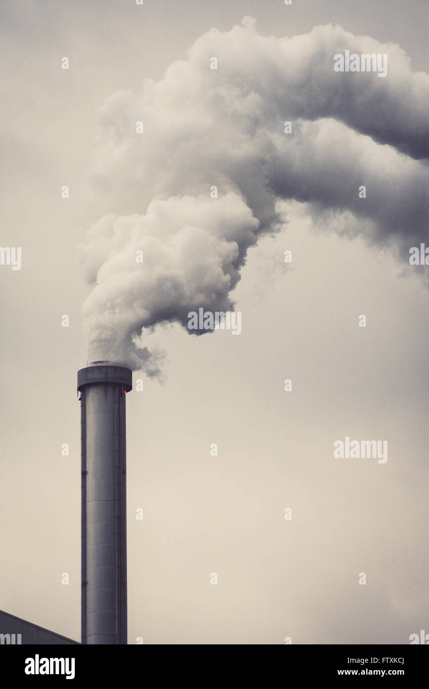 Une cheminée polluante avec une fumée grise Banque D'Images