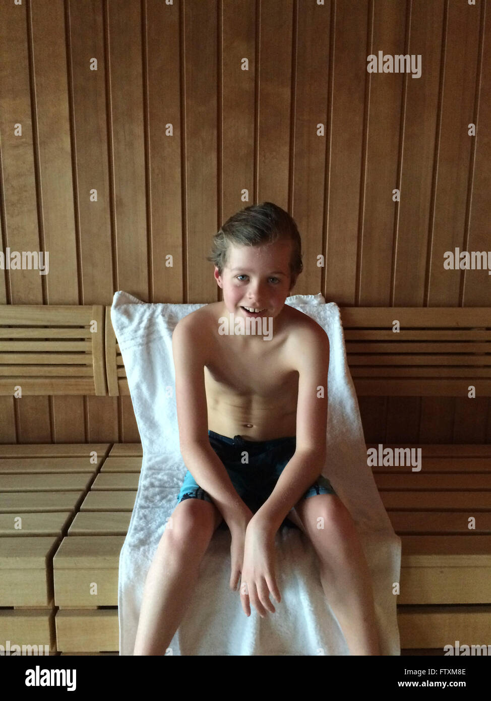 Garçon assis dans un sauna Banque D'Images