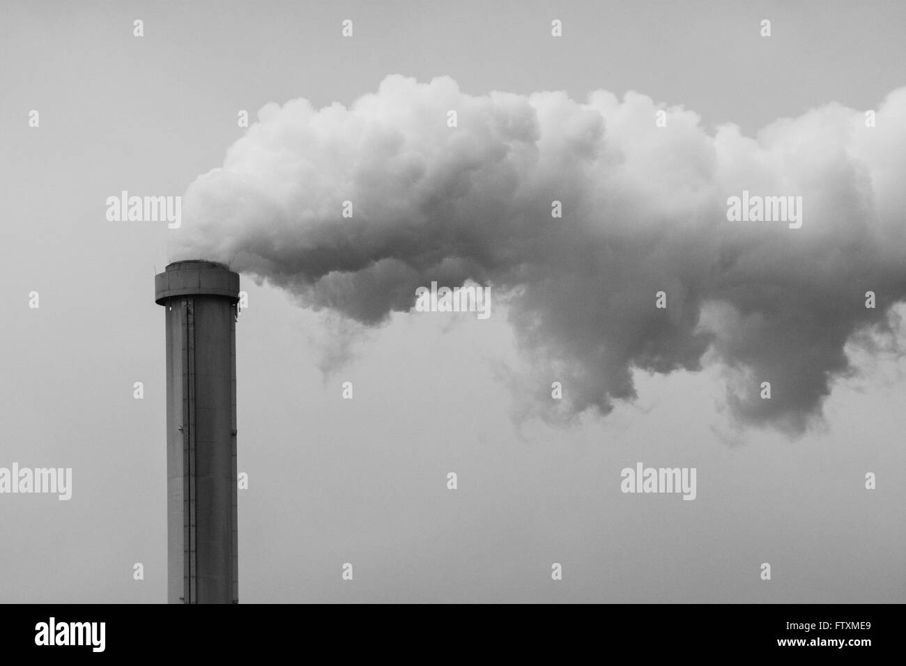 Une cheminée polluante avec une fumée grise Banque D'Images