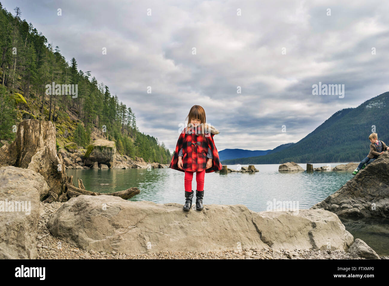 Jeune fille debout sur rock en river valley Banque D'Images