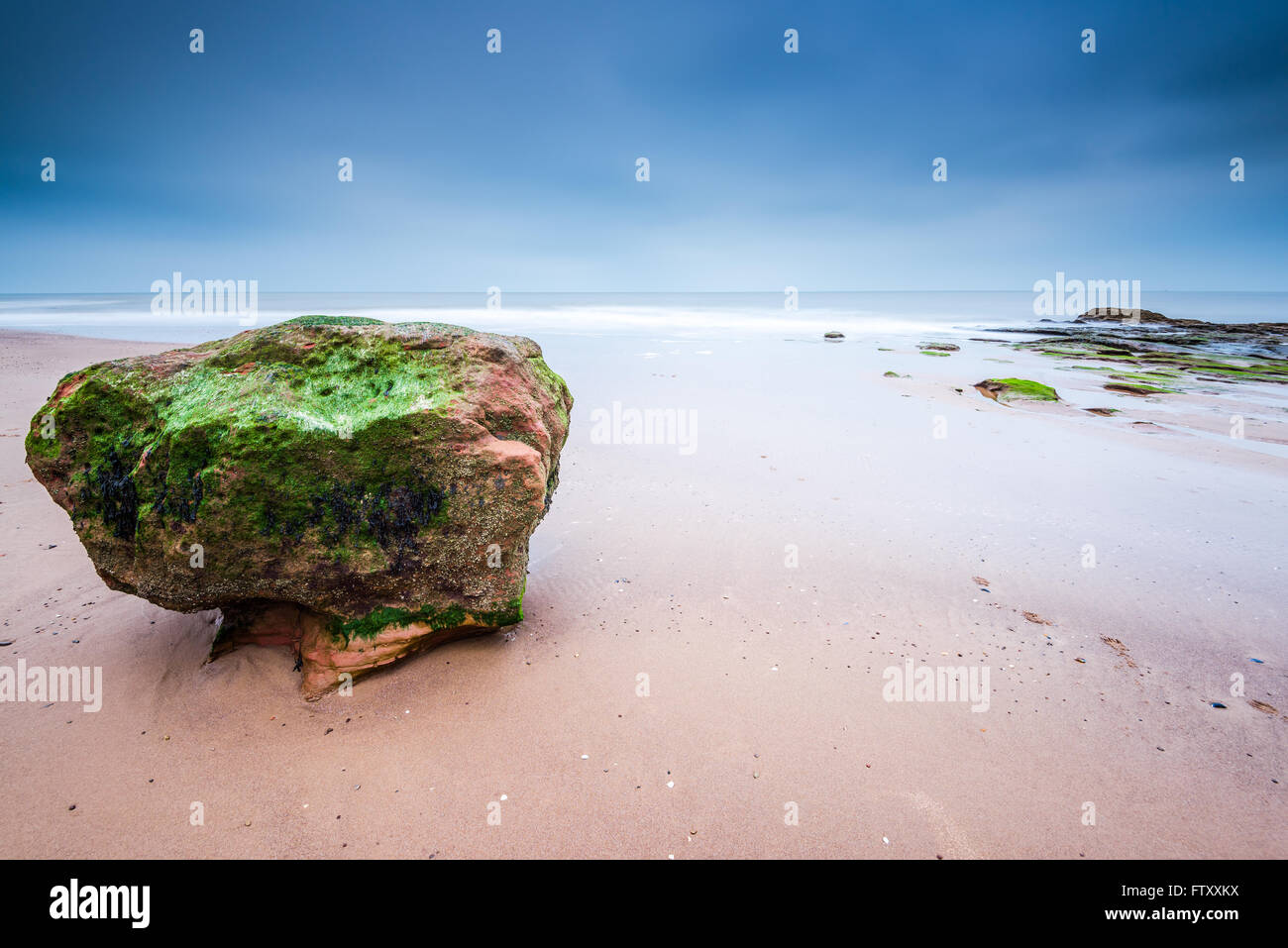 La formation de Red Rock Beach à Exmouth dans le Devon, Royaume-Uni. Une longue exposition blured l'eau de mer. Banque D'Images