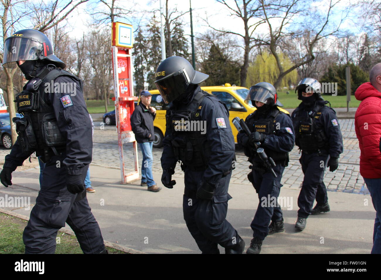 Les agents de police anti-émeute tchèque ont été vus garde Prague à l'occasion de la visite officielle du Xi Jinping à Prague et son itinéraire par la route prévue, puis rue Badeniho Chodkova Street, se dirigeant vers le château de Prague à rencontrer Milos Zeman. C'est rue Badeniho, près de Malostranska. Vous pouvez voir un résident local en attente d'un tram à Chodkovy Sady tram station. Le véhicule jaune à l'arrière-plan est un taxi local. Banque D'Images