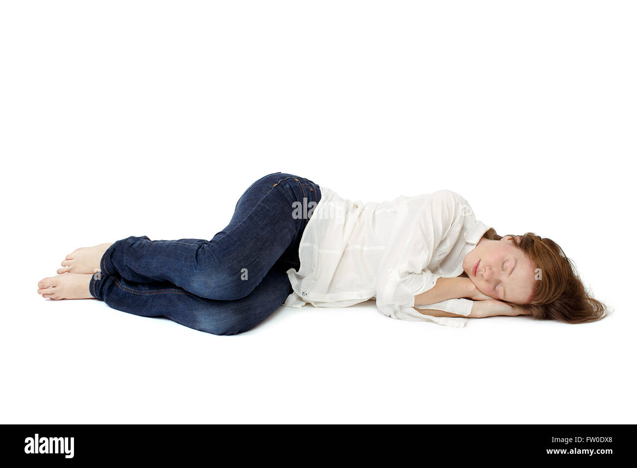 La jeune fille dormir dans ses vêtements sur le sol Banque D'Images