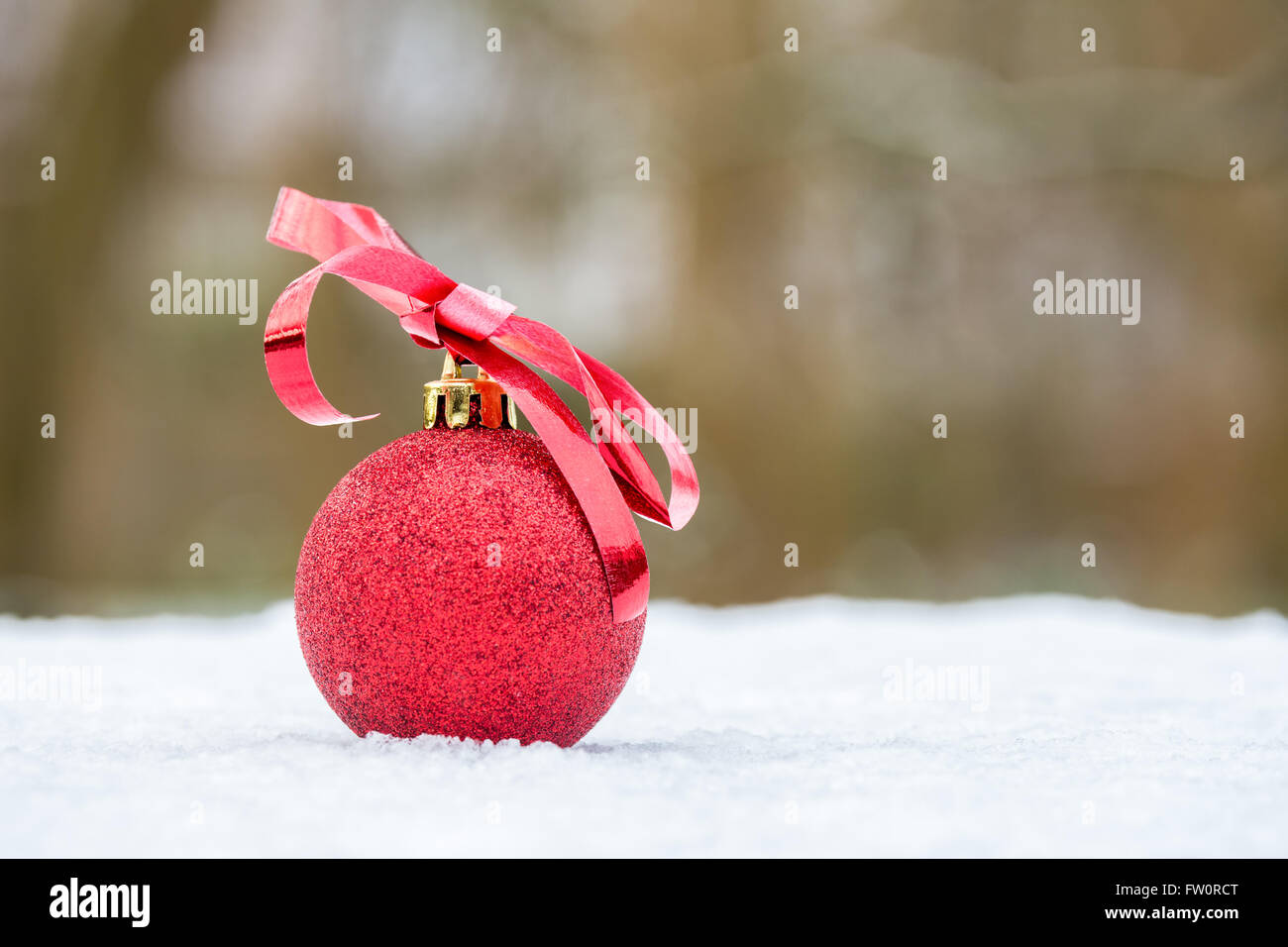 Boule de Noël rouge avec arc en plein air, sur la neige blanche Banque D'Images