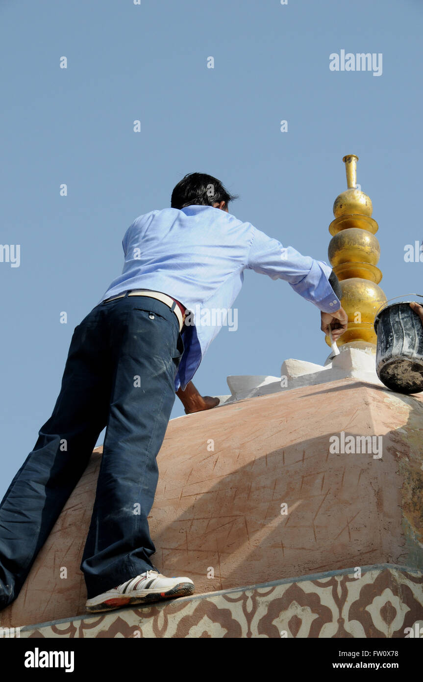 Un peintre met la touche finale à un dôme restauré au Fort Amber, Jaipur en Inde du Nord. Banque D'Images