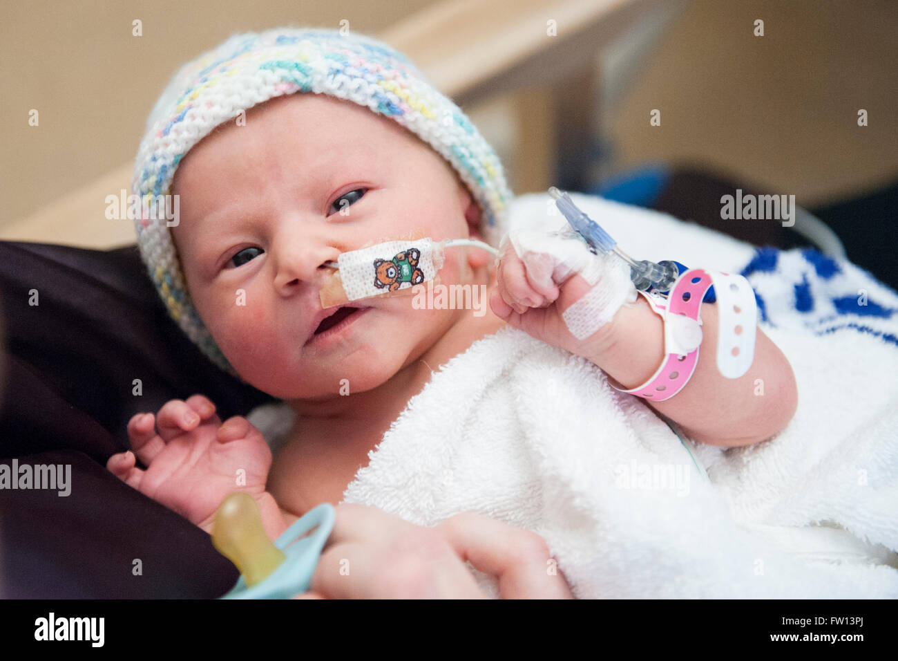 Un Gros Plan D Un Nouveau Ne Malade Baby Girl D Etre Tenu Dans Les Bras De Sa Mere Dans Une Unite De Soins Speciaux Avec Un Tube D Alimentation Dans Son Nez Photo Stock
