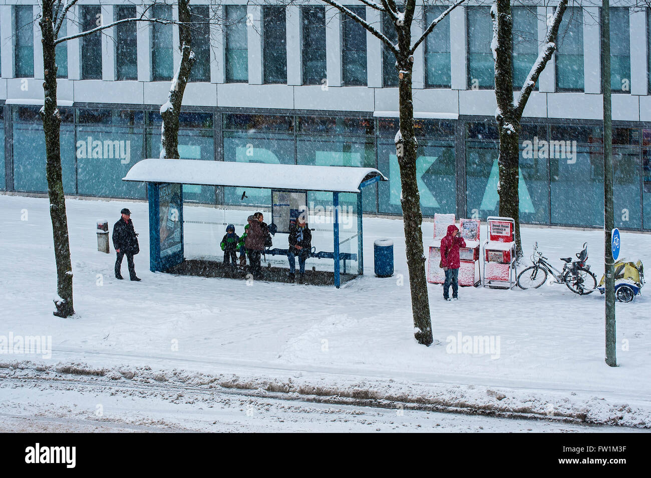 Les gens qui attendent dans un abribus au cours de neige, Munich, Bavière, Allemagne Banque D'Images