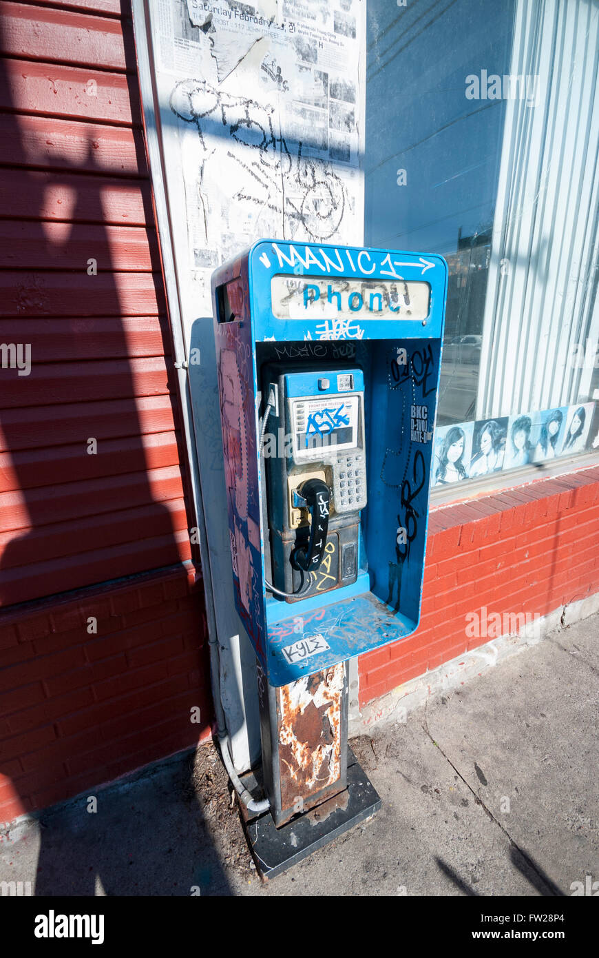 Un graffiti couverts et négligées, cabine téléphonique publique sur un coin de rue dans le quartier de Kensington Market Toronto Canada Banque D'Images