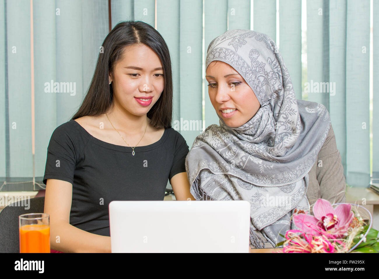 Les filles musulmanes de l'Asie et de travailler ensemble sur un ordinateur portable Banque D'Images