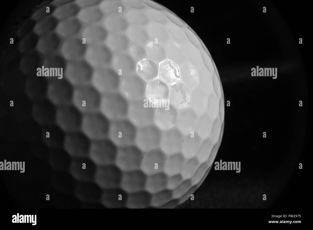 Close-up d'une balle de golf sur une surface en velours noir avec ombre portée Banque D'Images