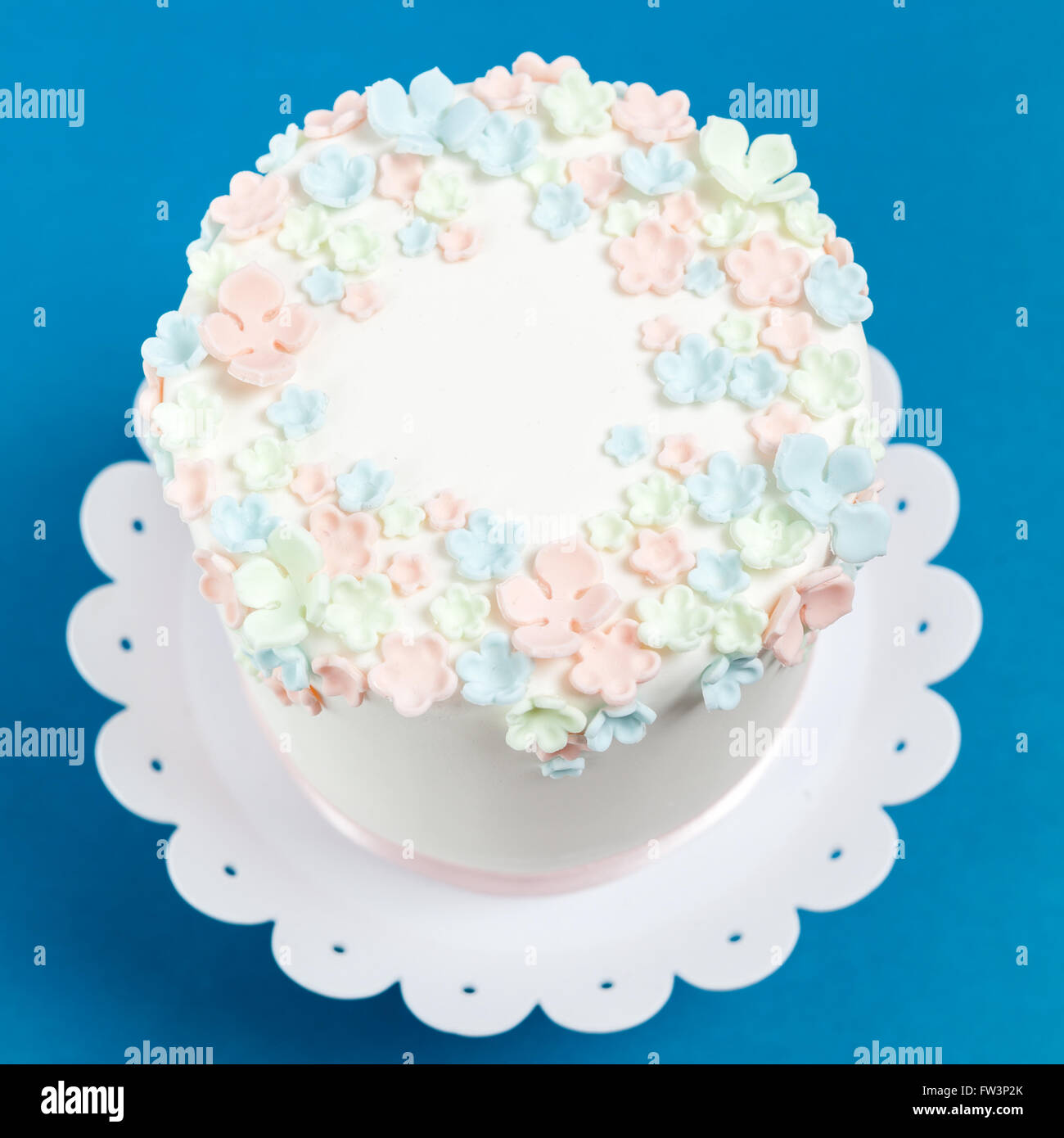 Gâteau décoré de fleurs de remplissage sur fond bleu Banque D'Images