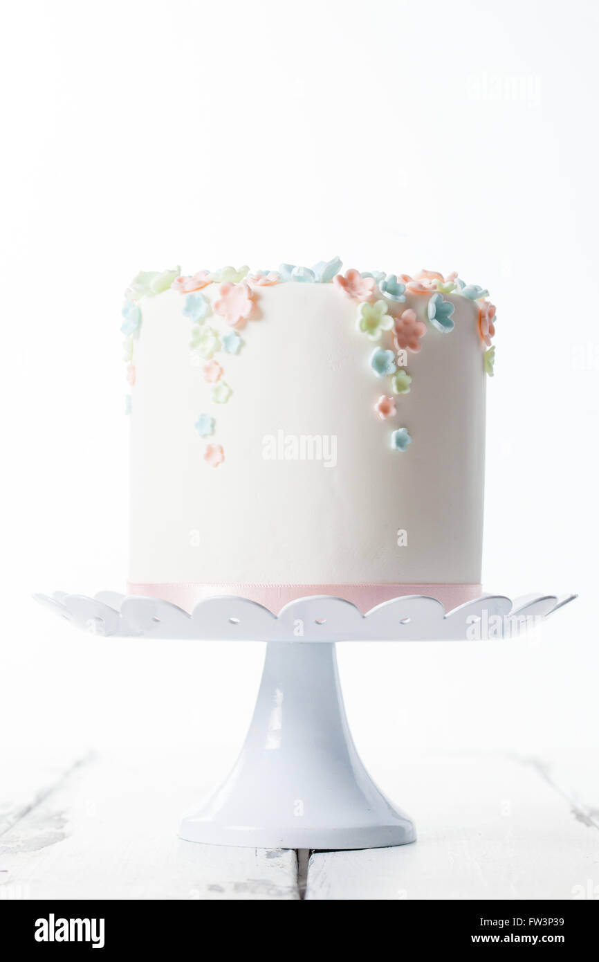 Le gâteau sur une plaque à gâteau avec décoration de couleur pastel Banque D'Images