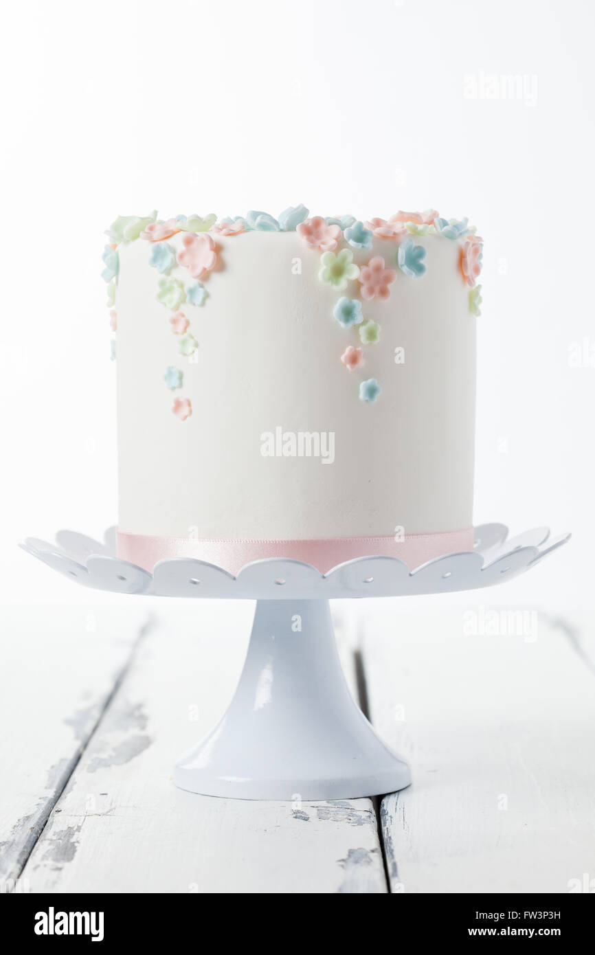 Gâteau sucré avec fleur sugarcraft couleur pastel sur une plaque Banque D'Images