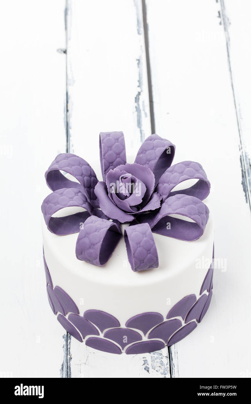 Joli gâteau décoré avec un archet sur lilas vintage légèrement au-dessus de l'arrière-plan Banque D'Images