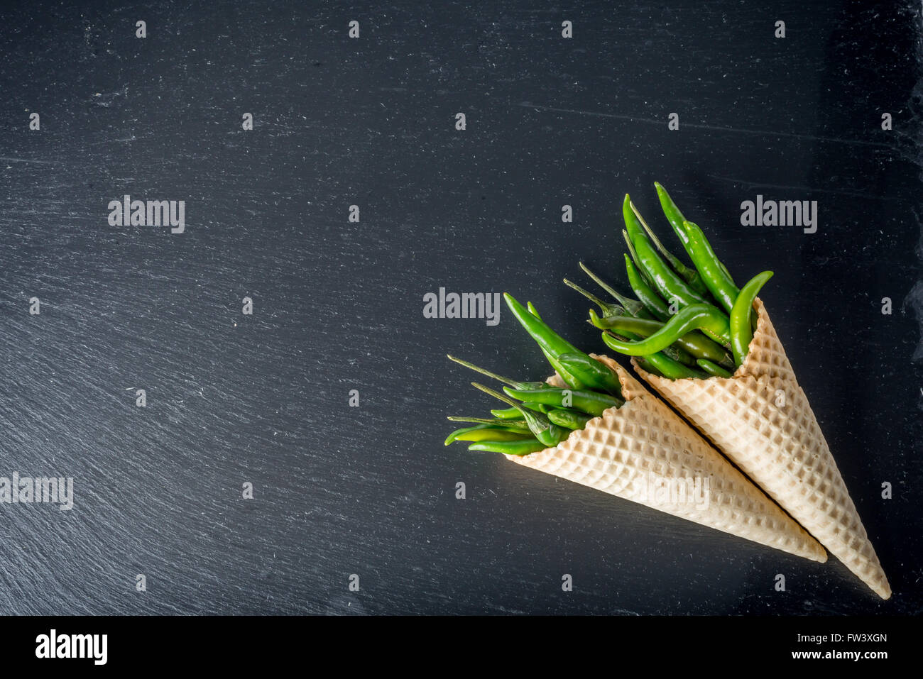 Piment vert cru dans les cônes gaufrette sur bac en ardoise noire Banque D'Images