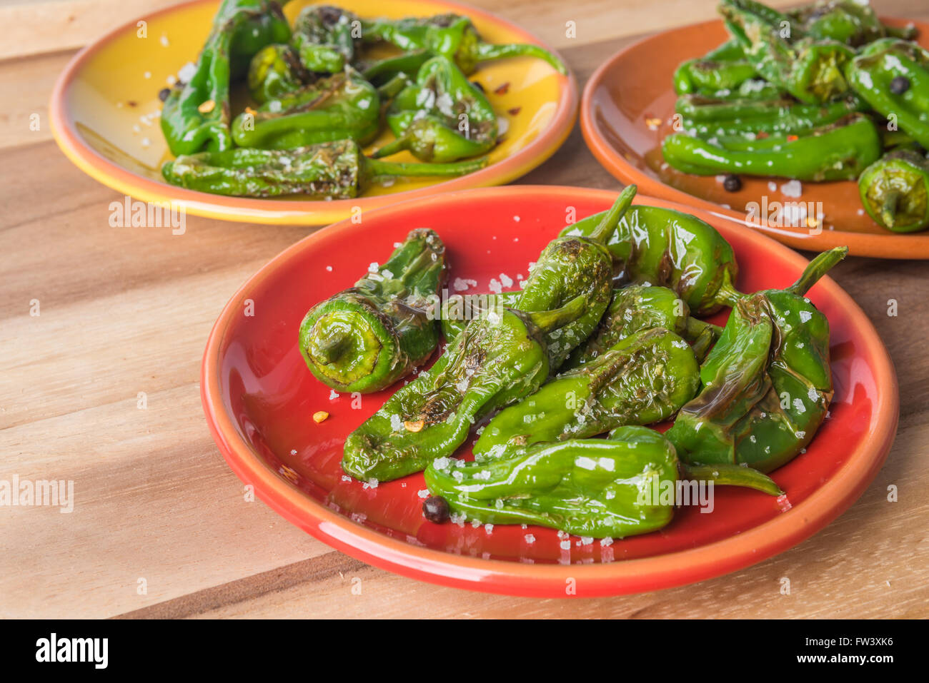 Poivrons grillés padron avec sel et poivre sur les plaques colorées Banque D'Images