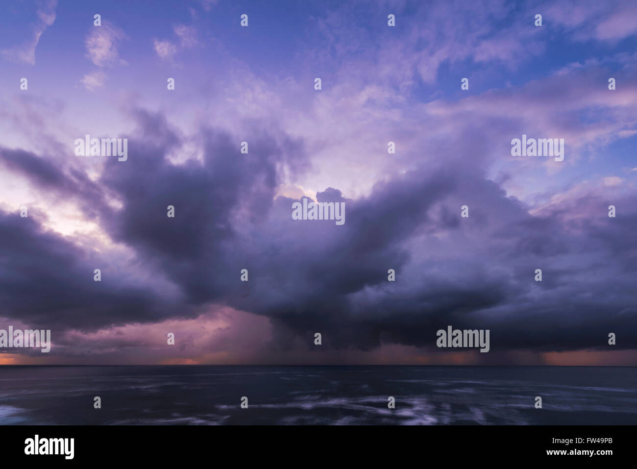 Approche de l'orage avec pluie nuages sur la mer au lever du soleil Banque D'Images