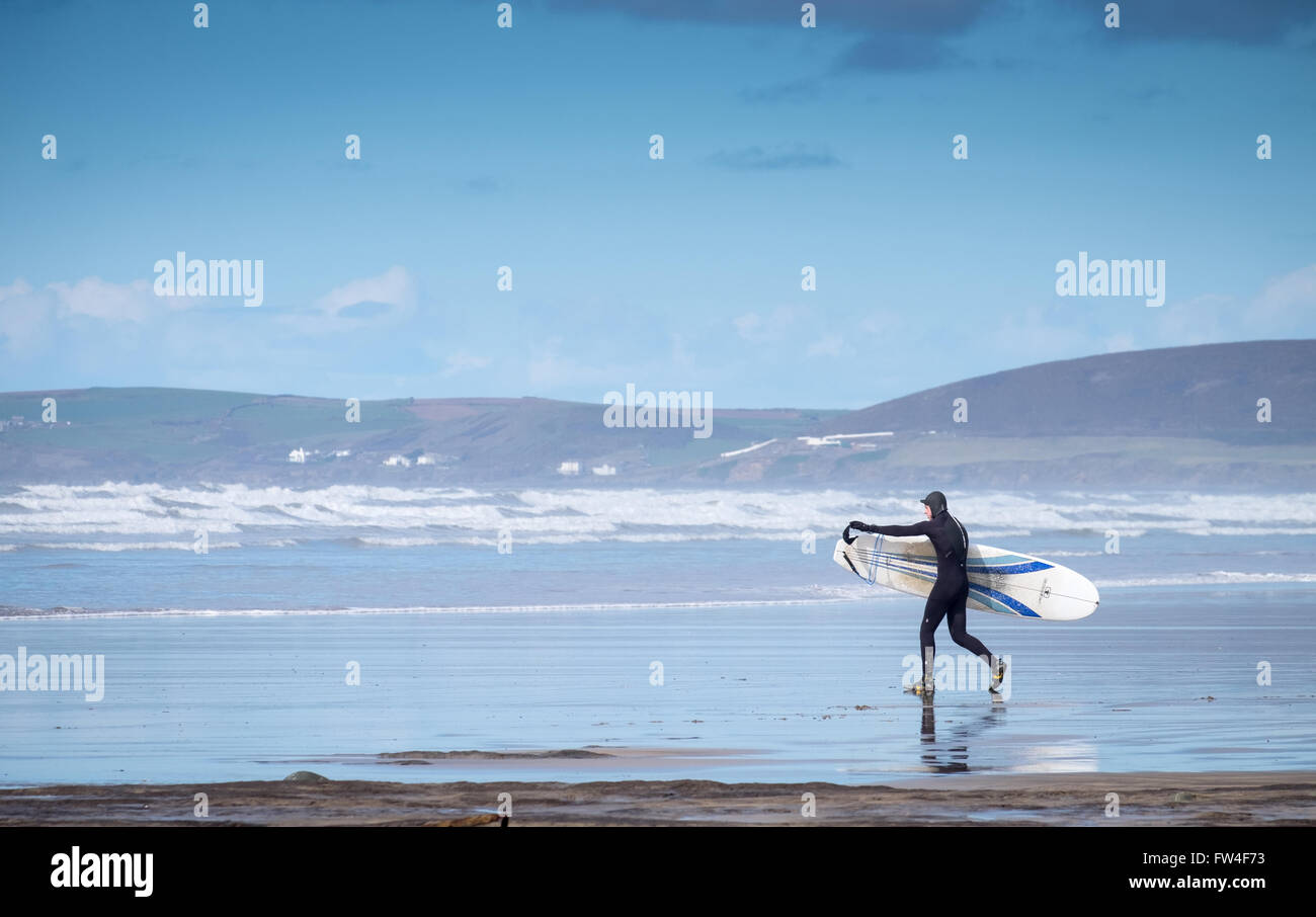 Un surfeur sur la plage à Westward Ho ! Dans le Devon, England, UK Banque D'Images