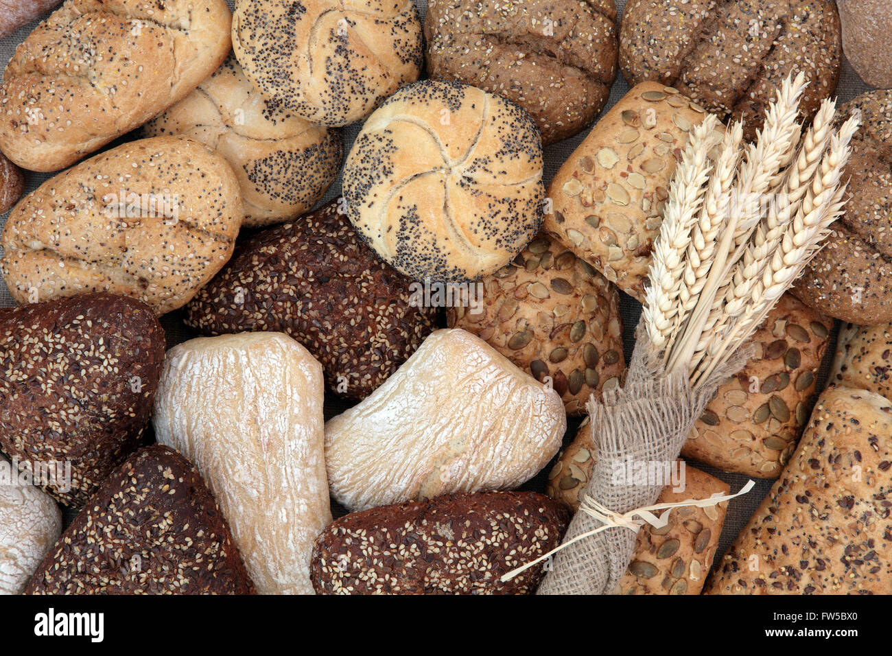 Sélection de petits pains de blé avec gaine de hessian formant un motif de fond. Banque D'Images