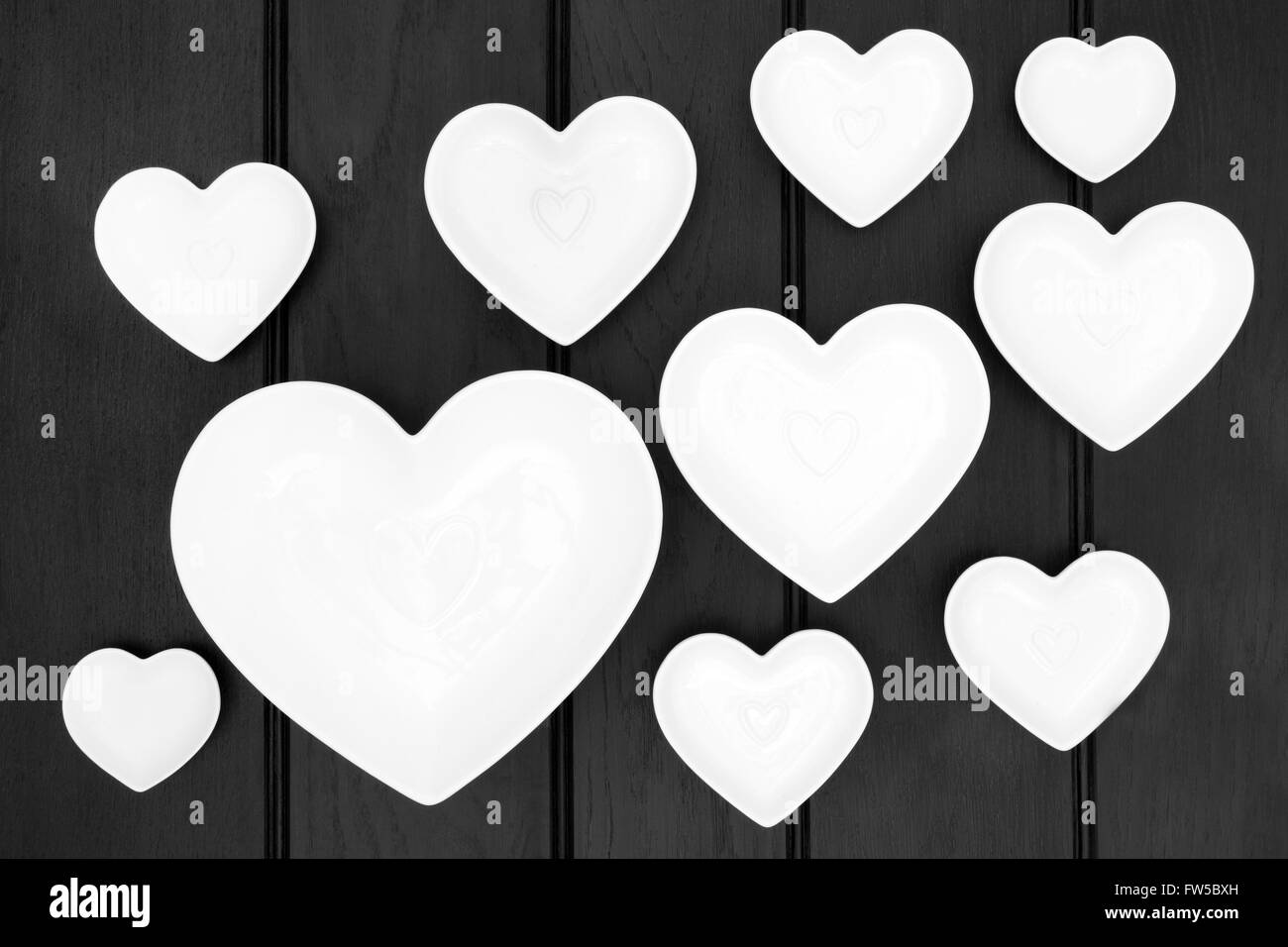 Plats en forme de coeur en porcelaine sur fond en bois sombre. Banque D'Images