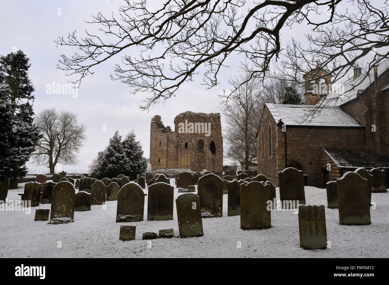 Bowes Église, les ruines du château, et des tombes sous la neige, sur le Yorkshire Moors (maintenant dans le comté de Durham), par la A66. Ici sont enterrés l'original de Smike, compagnon de Nicholas Nickleby dans le roman de Charles Dickens, auteur anglais, et William Shaw, directeur, avec 8 élèves de William Shaw's Academy, l'un de plusieurs écoles de la région et offre des vacances sans 'scolarité' pour les enfants non désirés, souvent à partir de Londres. Dickens a fait une visite spéciale à travers la neige épaisse en février 1838, et dénoncé la cruauté et les conditions épouvantables dans son roman, le directeur de dénomination soigneusement 'Wackford Banque D'Images