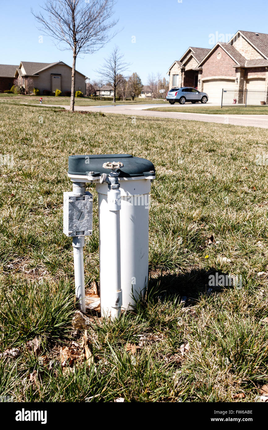Un compteur d'eau avec un robinet dans un quartier cour. USA. Banque D'Images