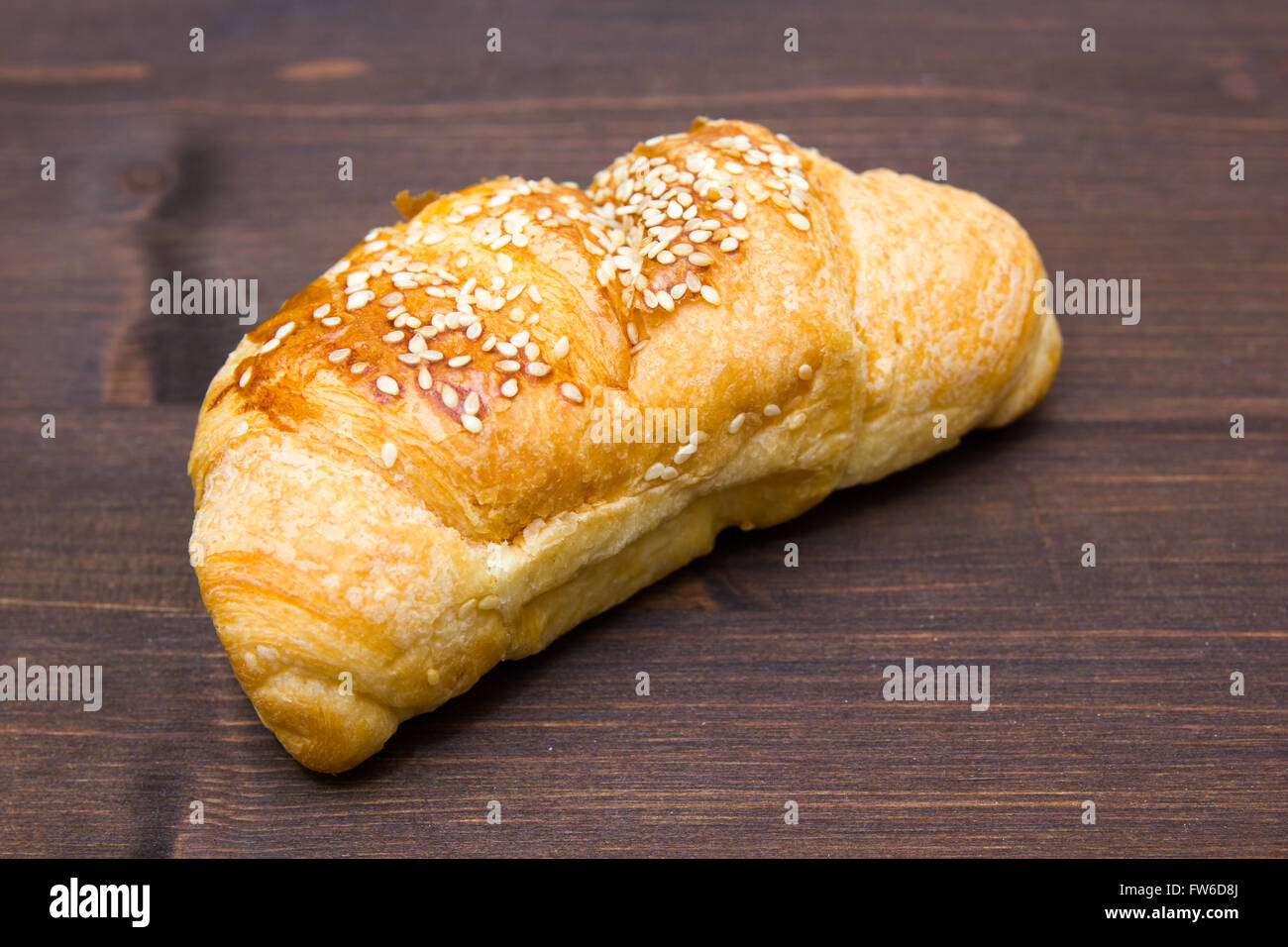 Croissant salé sur une table en bois sombre. Banque D'Images