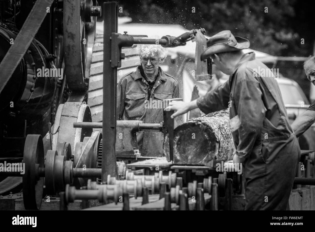 3 Les hommes qui travaillent sur une machine de coupe de bois à vapeur Banque D'Images