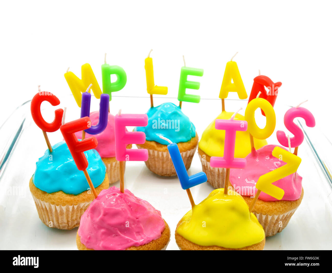 Cupcakes d'anniversaire avec des bougies joyeux anniversaire en espagnol Banque D'Images