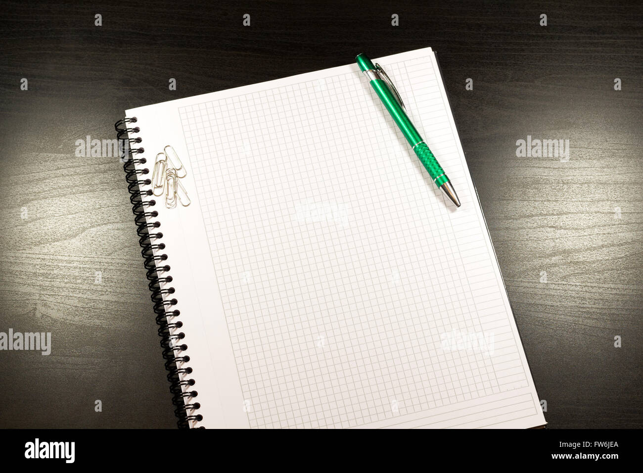 Ordinateur portable avec le papier blanc, la couleur des notes, un stylo et des clips sur une table en bois Banque D'Images