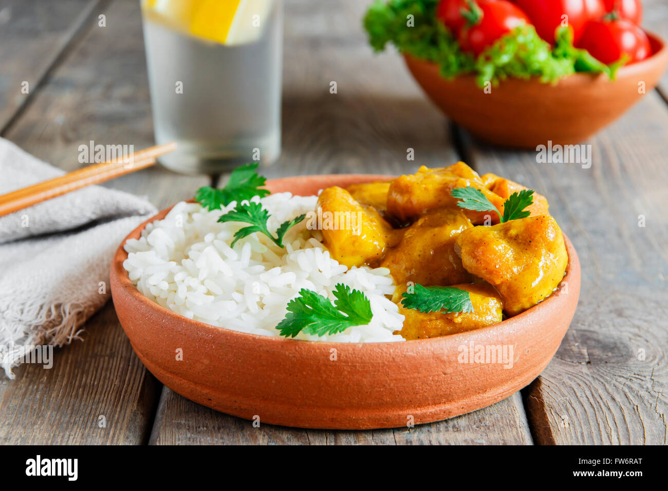 Poulet au curry avec du riz sur une surface en bois Banque D'Images