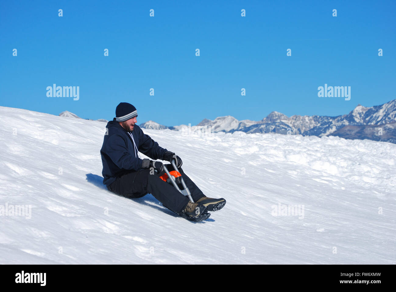 Dans l'homme sur une moto luge traîneau sur une colline de neige allant  jusqu'à rire Photo Stock - Alamy