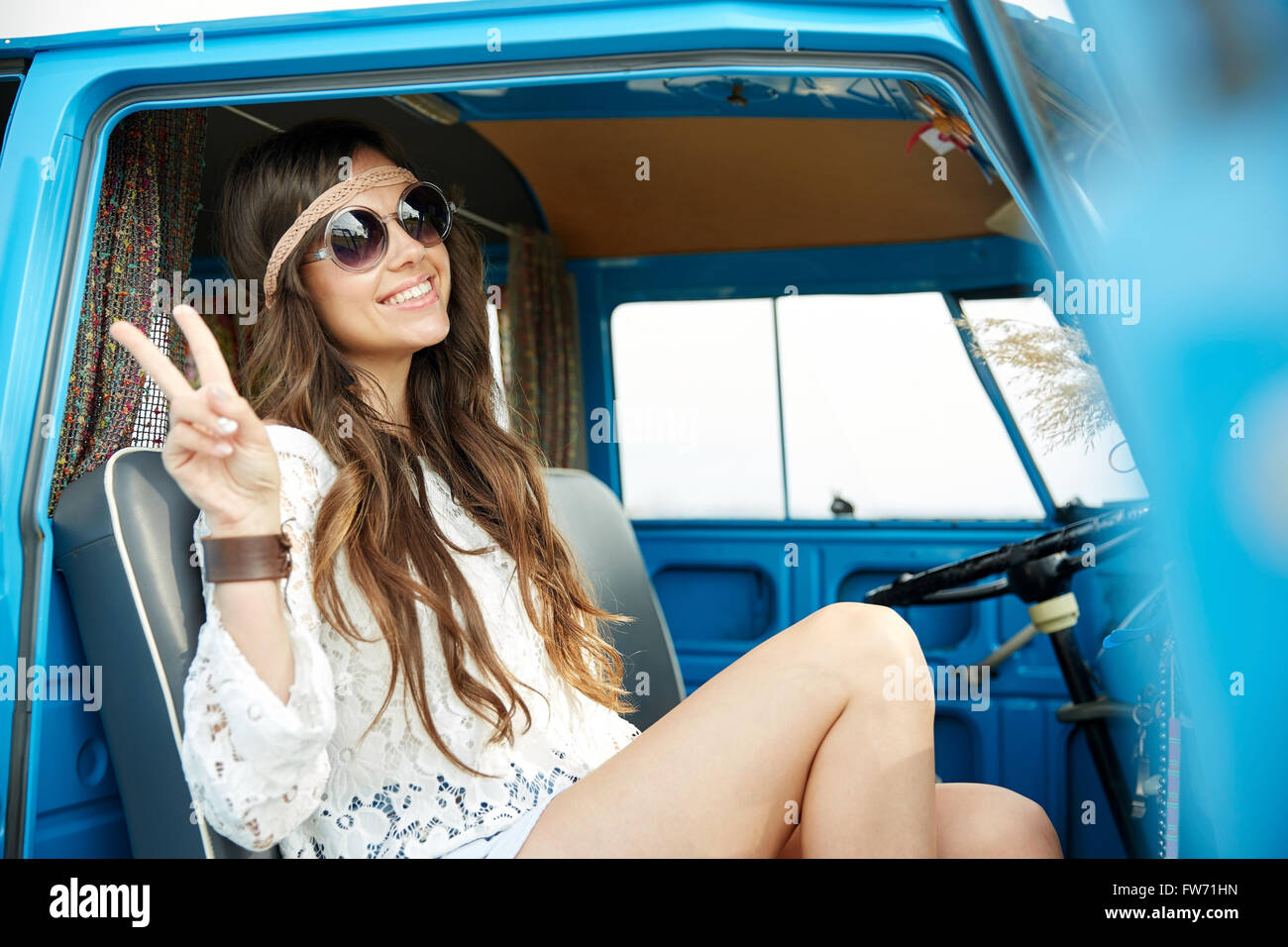 Femme hippie heureux montrant la paix en voiture fourgonnette Banque D'Images